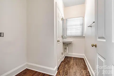 Convenient powder room off the kitchen with hardwood floors, sink & adjacent space for a second refrigerator or custom drop zone.