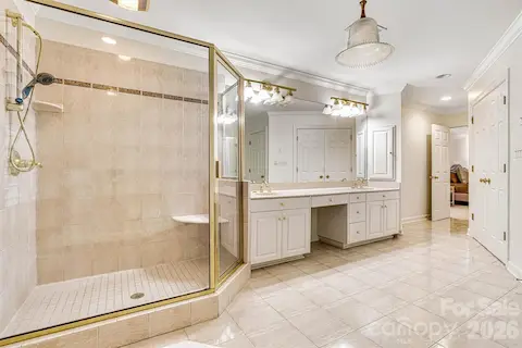 Double vanities, gleaming tile floors & a spacious walk-in shower.
