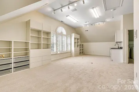 Expansive bonus room with recently installed neutral carpet, floor outlets, plantation shutters, custom built-ins & wet bar and lots of added lighting.