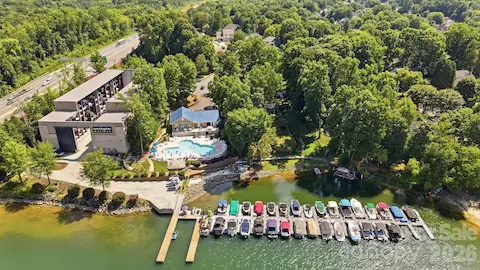 Nearby community amenities include a full-service marina and resort-style pool overlooking the water. This aerial perspective showcases the convenience of boating access, marina facilities, and a spacious pool deck for relaxing and gathering by the lake.