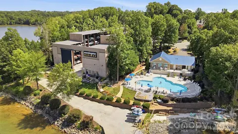 A closer aerial view of the marina complex highlights covered boat storage, waterfront access, and the adjoining clubhouse and pool area. Together, these amenities enhance the Lake Norman lifestyle with convenient options for boating, recreation, and time spent outdoors.