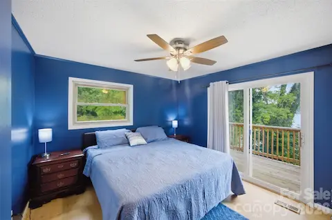 Primary bedroom with private deck and wonderful lake views!