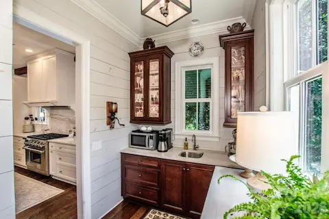 Butlery with built in hutch cabinet with glass doors with lights and a handy prep sink