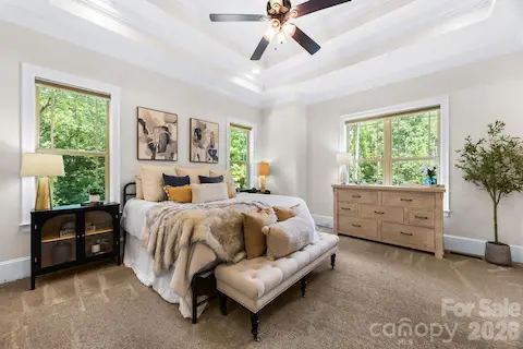Primary bedroom off living room with tray ceilings