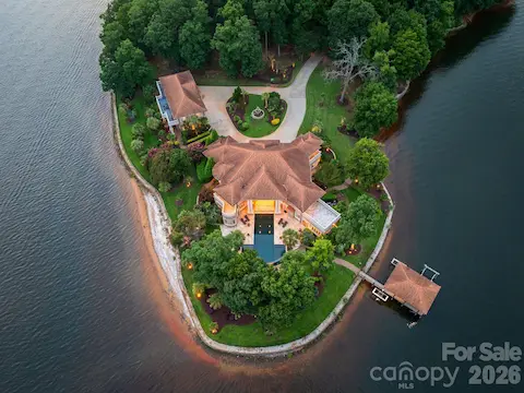 Stunning aerial showcasing the home’s private peninsula setting surrounded by expansive Lake Norman shoreline.