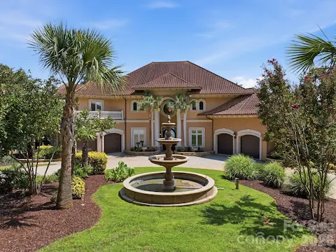 Beautifully landscaped front grounds feature a circular fountain and impressive architectural details.