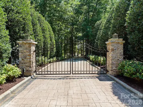 Gated entrance with stone columns and mature landscaping offers privacy from the moment you arrive.