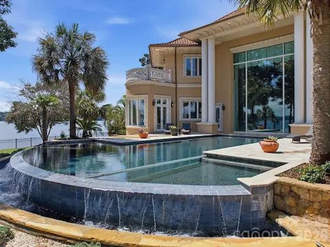 Elevated spa and infinity-edge pool form a dramatic centerpiece along the rear of the home.