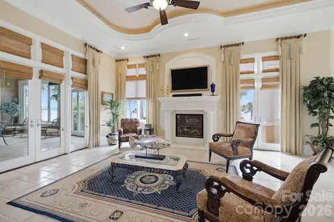 Inviting sitting room features a cozy fireplace, abundant natural light and an elegant space to relax and unwind.