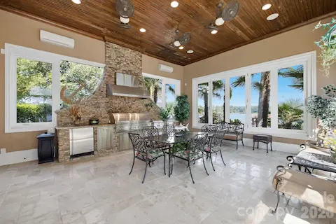 Conditioned Sunroom designed for year round enjoyment with a built-in grilling area and folding windows that open to create a seamless indoor-outdoor entertaining space.