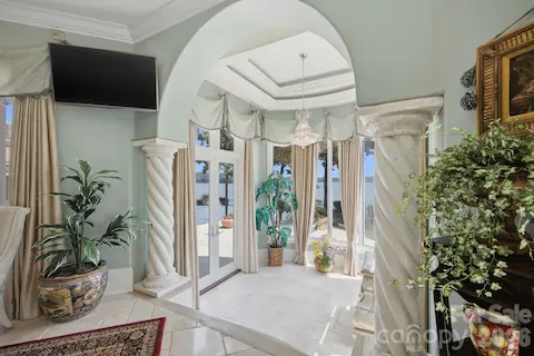 Spacious primary suite features detailed ceiling treatments, abundant natural light and an elegant sitting area.