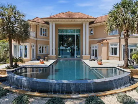 Stunning rear aerial highlights the massive resort-style pool and expansive outdoor living areas overlooking Lake Norman.