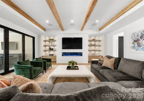 The living room features lighted built in shelving and a plaster feature wall with 75" integrated gas fireplace.