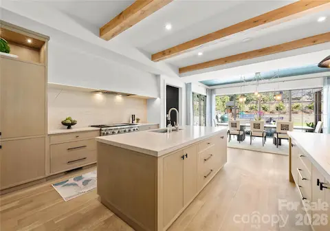 The kitchen features gorgeous quartzite countertops and uninterrupted slab backsplash with a hand applied plaster hood over the range.