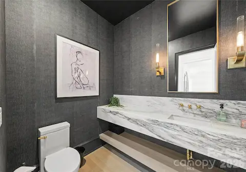 Guest powder room with floating marble vanity and designer wall covering.