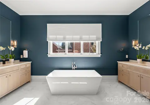 Primary bath with floating tub, motorized shade, and dual vanities with beautiful fluted detailing.
