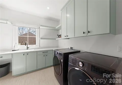 Laundry room with sink, linen closet, and additional walk in storage closet with shelving.