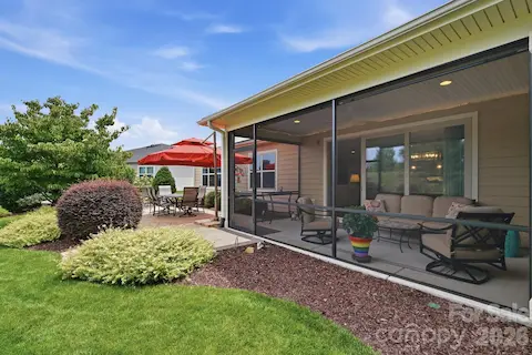 A large screened porch creates another comfortable living space surrounded by beautiful landscaping.