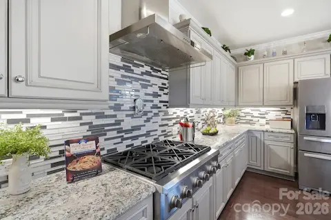 Six-burner gas cooktop with stainless hood and cast-iron grill insert brings serious cooking capability home.
