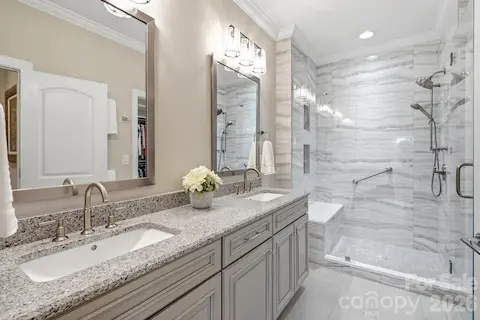 The primary bath pairs dual vanities with beautiful finishes and a spacious walk-in shower.