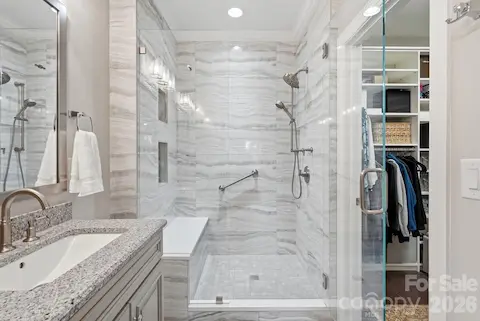 Gorgeous walk-in shower with bench seating creates a comfortable, spa-inspired retreat.