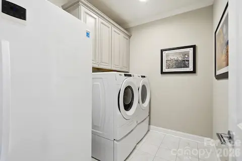 Dedicated laundry room with cabinetry and the washer and dryer are included.