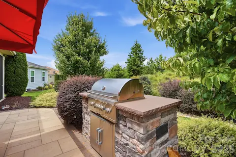 Built-in stone natural gas grill makes outdoor cooking part of the backyard experience.