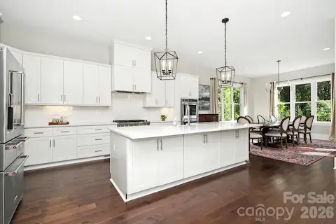 Beautiful kitchen with updating lighting, countertops, back splash, gas range-vent hood, sink and fixtures