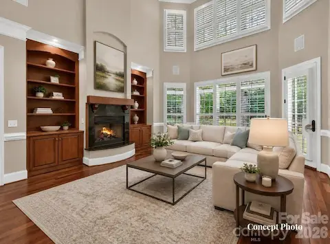Concept photo of virtually staged stunning two-story great room features soaring ceilings, custom built-ins, expansive windows, and a cozy fireplace with seamless flow into the kitchen and breakfast area.