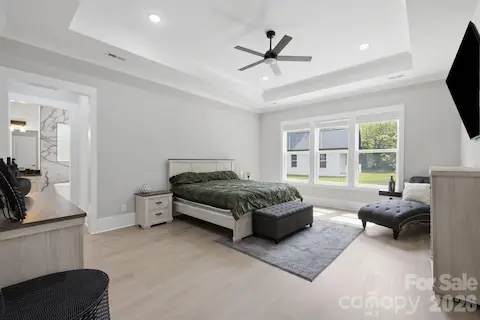 Spacious primary suite with tray ceiling and abundant natural light
