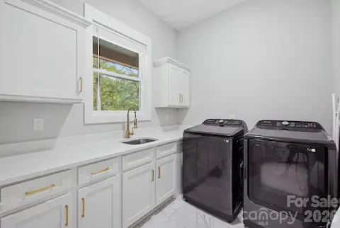 Convenient main-level laundry room with cabinetry and utility sink