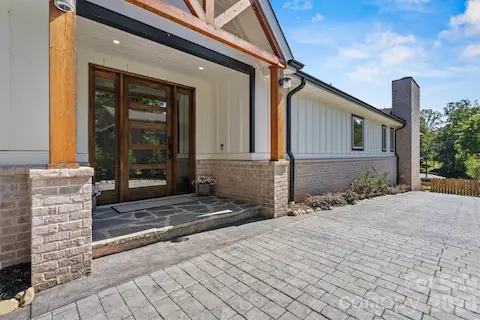 Stamped drive to oversized solid-wood front door and to rear yard.