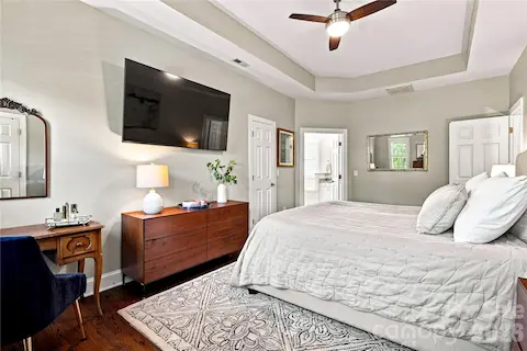 Primary bedroom with tray ceiling and 2 WIC