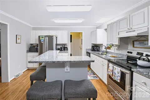 Updated kitchen with granite countertops, center island and white countertops