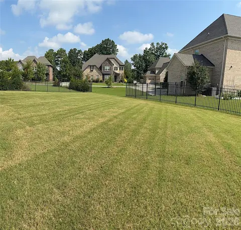 Spacious Backyard (alternate view) w/3 sided wrought iron fencing. Owner previously had invisible fencing where the open spacing is located.
