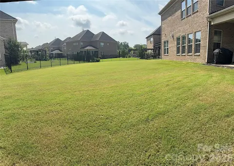 Spacious Backyard (alternate view) w/3 sided wrought iron fencing. Owner previously had invisible fencing where the open spacing is located.
