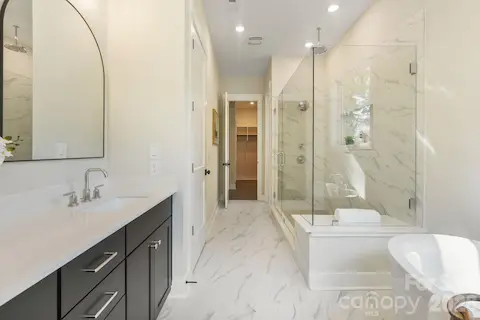 Spa like primary bathroom features rain shower and soaking tub