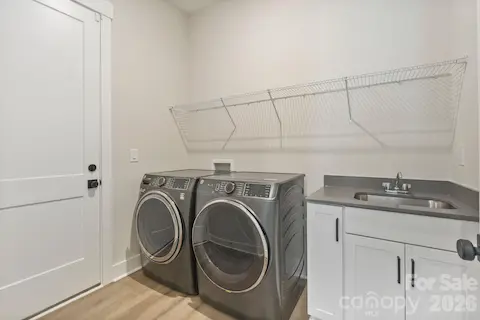 Spacious laundry room includes washer, dryer, and utility sink
