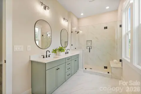 Walk-in tile shower and dual vanities