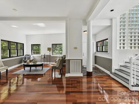 An open, light-filled interior welcomes you with gleaming Brazilian hardwood floors, abundant windows, architectural details, and a dramatic glass-block staircase.