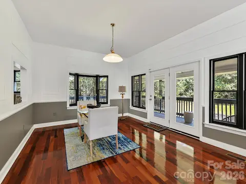 Bright dining area with Brazilian hardwood floors, walls of windows, and direct access to the covered outdoor living space overlooking the private Davidson acreage.