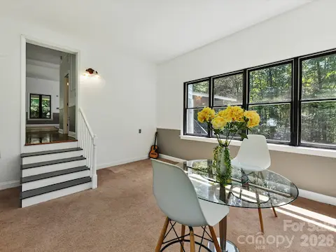 Versatile sunroom or flex space offers abundant natural light, panoramic wooded views, and endless possibilities for dining, office, or additional living space.