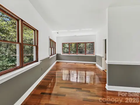 The bright primary bedroom offers beautiful Brazilian hardwood flooring, expansive windows, and generous space for a comfortable bedroom retreat.