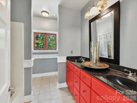 Full bath features tile flooring, generous vanity space, and classic architectural trim details.