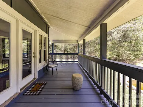 Spacious covered balcony provides a peaceful outdoor retreat overlooking the private, wooded surroundings.