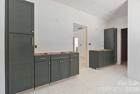 The primary ensuite bath has gorgeous green cabinetry, quartz counters, tile flooring, an oversized walk-in tile shower and soaking tub.