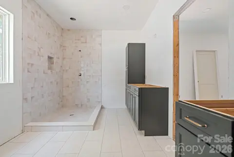 This primary bath has separate vanities, each with their own closets.  The pretty tile shower, frameless glass, and soaking tub complete the space.
