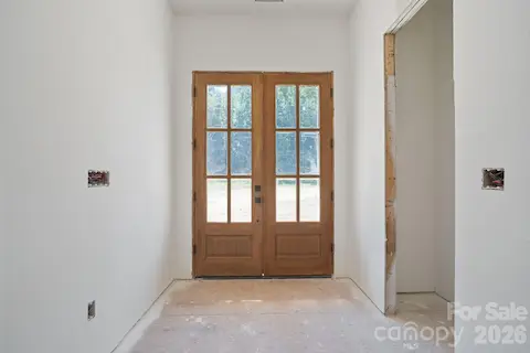 Welcoming foyer with closet. Beautiful wood-stained doors letting natural light pour in.