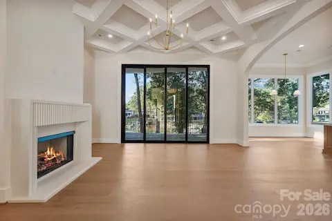 Family room featuring soaring 12' ceilings and a custom diamond-coffered ceiling that adds architectural detail and character.