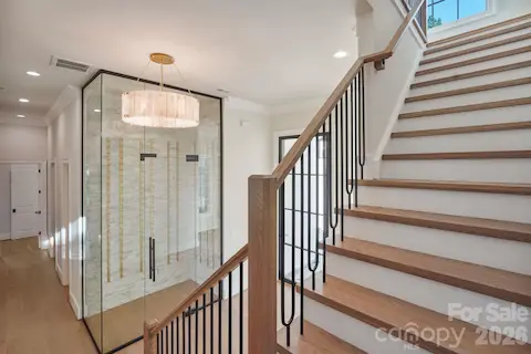 Dramatic 12' glass-enclosed wine room featuring a custom glass door with hydraulic operation for added safety and security.